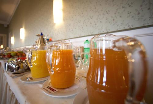 three glasses of orange juice sitting on a counter at Boutique Hotel Bellevue in Interlaken