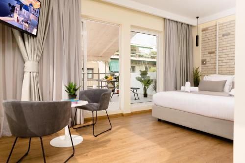 a bedroom with a bed and a table and chairs at SUITES@SYNGROU-FIX in Athens