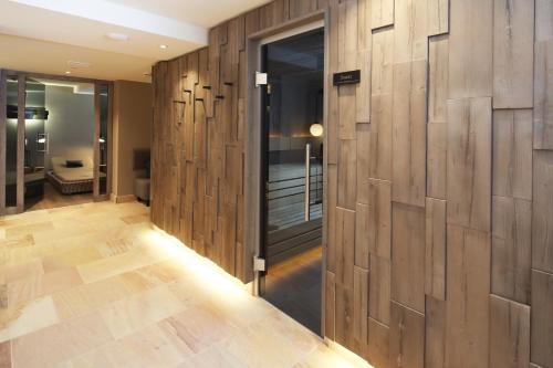 a hallway with wood paneled walls and a room with a bathroom at Landhaus Severin's Morsum Kliff in Morsum