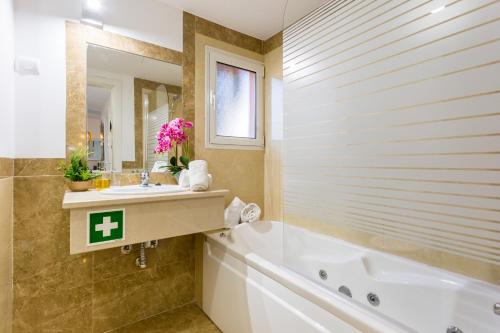 Un baño con bañera, lavabo y bañera. en MUSSULO BEACH APARTMENT litoralmar, en Portimão