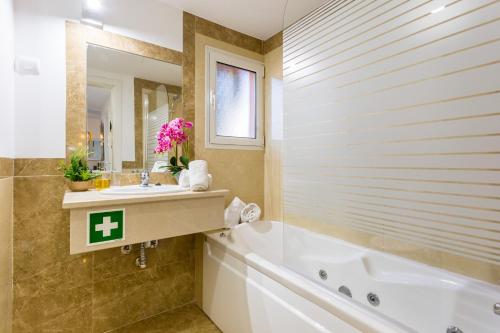 a bathroom with a tub and a sink and a bath tub at MUSSULO BEACH APARTMENT litoralmar in Portimão