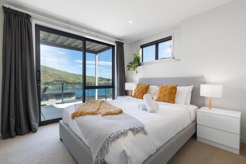 a bedroom with a large bed and a large window at Alpine Getaway in Queenstown