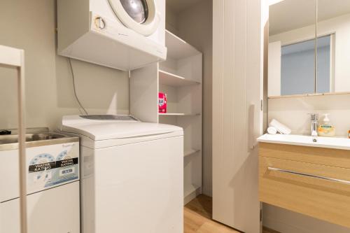 a small kitchen with a washer and dryer at Alpine Getaway in Queenstown
