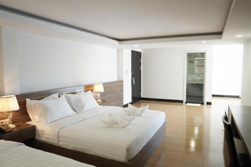 a bedroom with two beds with white pillows at Apple Hotel Three - Phnom Penh in Phnom Penh
