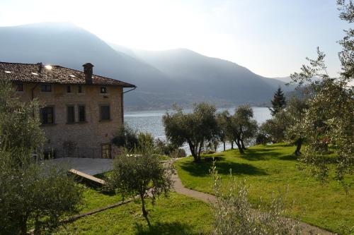 a house on a hill next to a body of water at Castello Oldofredi in Monte Isola