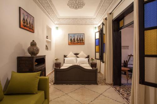 1 dormitorio con cama, sofá y chimenea en Riad 111 & Spa, en Marrakech