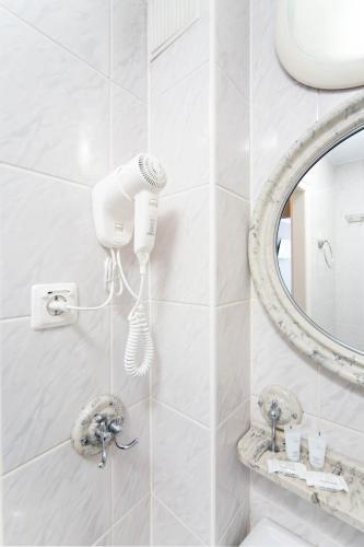 a bathroom with a blow dryer and a mirror at Hotel Mazowiecki Łódź in Łódź