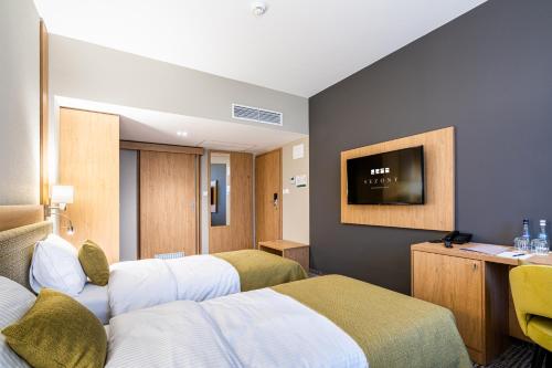 a hotel room with two beds and a flat screen tv at Sezony. Restauracja i Hotel in Kostrzyn