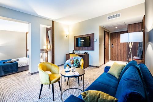Sezony. Restauracja i Hotel في كوسترزين: غرفة معيشة مع أريكة زرقاء وطاولة
