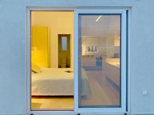 una porta scorrevole in vetro che conduce a una camera con letto di Kolonaki Terrace ad Atene