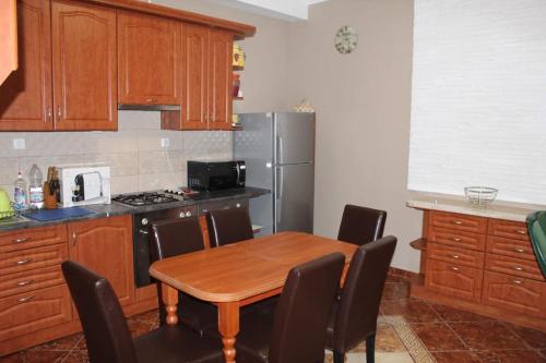 uma cozinha com uma mesa de madeira e um frigorífico em Chill House em Miskolc
