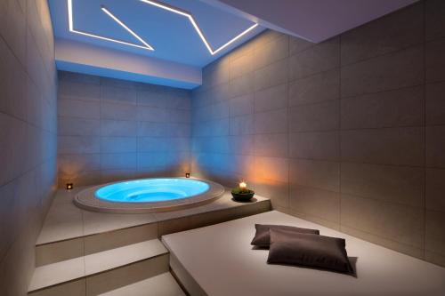 uma casa de banho com jacuzzi e tecto azul em Mamaison Residence Downtown Prague em Praga