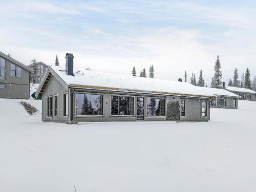 ein Haus mit schneebedecktem Dach im Schnee in der Unterkunft 10 person holiday home in F vang in Favang