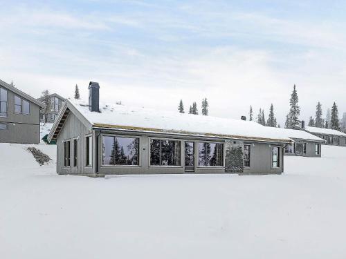 a house in the snow with a lot of windows at 10 person holiday home in F vang in Favang