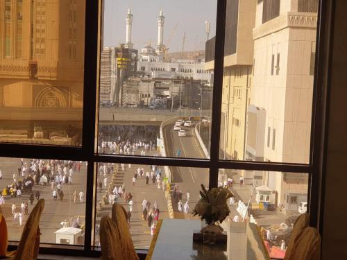 a view of a city from a window with a table at Maysan Al Mashaer Hotel in Makkah