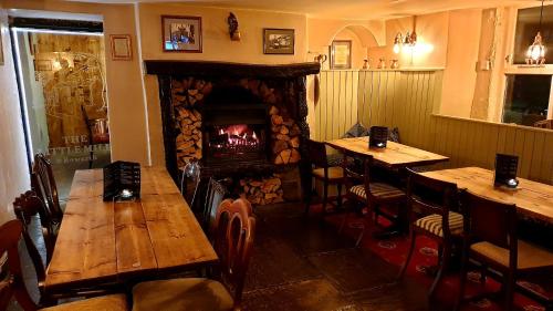 um restaurante com duas mesas e uma lareira em The Little Mill Inn em New Mills