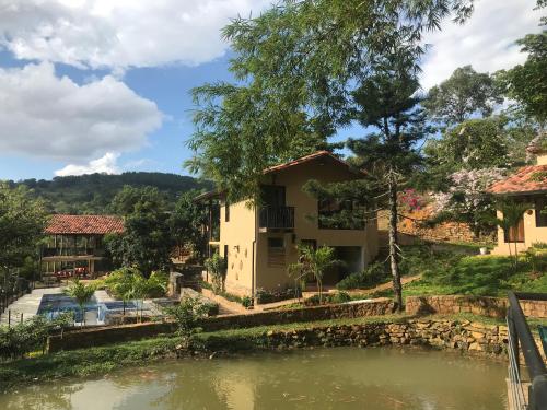 a house with a pond in front of it at Hotel Casas de Campo El Ciruelo in San Gil
