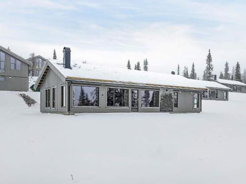 10 person holiday home in F vang في Favang: منزل في الثلج مع الكثير من النوافذ