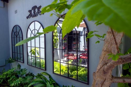 a group of windows on a building with plants at La Fontaine Boutique Hotel by The Oyster Collection in Franschhoek