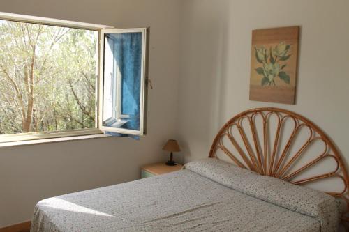 a bedroom with a bed and a window at Rena Garden Apartments in Rena Majore