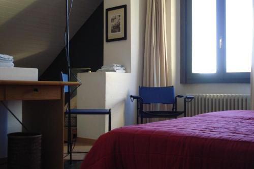 a bedroom with a bed and two blue chairs at Albergo della Posta in Astano