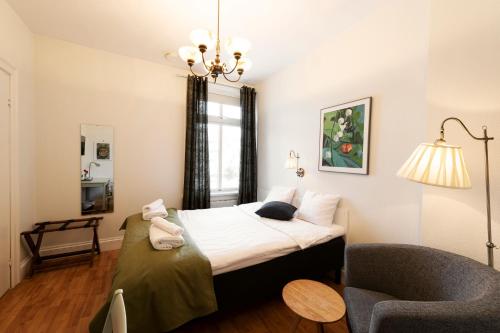 a small bedroom with a bed and a chair at SPiS Hotell Amber in Luleå