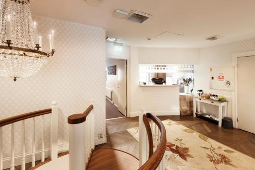 a dining room and kitchen with a chandelier at SPiS Hotell Amber in Luleå