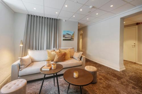 a living room with a couch and two tables at SPiS Hotell Amber in Luleå