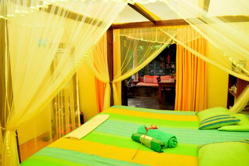 a bedroom with a green bed with curtains at Villa Prias by Amrea in Aluthgama
