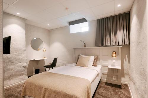 a hotel room with a bed and a mirror at SPiS Hotell Amber in Luleå