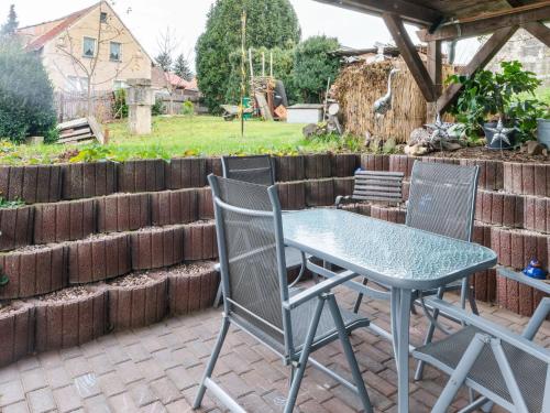 une table et des chaises assises sur une terrasse dans l'établissement Holiday home with terrace and fenced garden, à Naumbourg