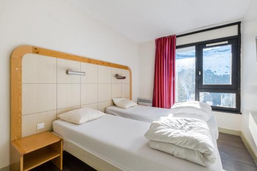 2 Betten in einem Zimmer mit Fenster in der Unterkunft Residence La Foret - maeva Home in Arâches-la-Frasse