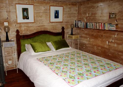 a bedroom with a bed with a wooden wall at Maison du chat bleu in Saint-Hilaire-de-Clisson