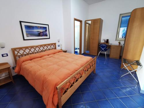a bedroom with a bed with an orange comforter at Al Baglio in Mondello