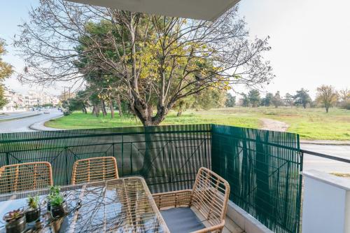 a balcony with two chairs and a table and a tree at Grand Lux Apartment in Serres