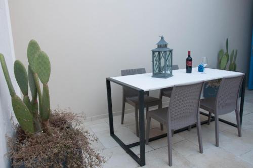 tavolo da pranzo con sedie e bottiglia di vino di La Torre GMA Tourism a Torre Lapillo