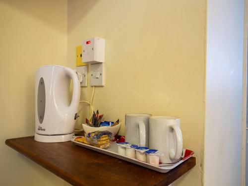 a shelf with a coffee maker and cups on it at Longforgan Coaching Inn in Dundee