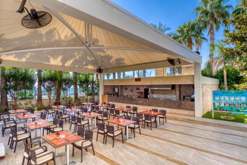 einen Essbereich im Freien mit Tischen und Stühlen in der Unterkunft Porto Bello Hotel Resort & Spa in Antalya