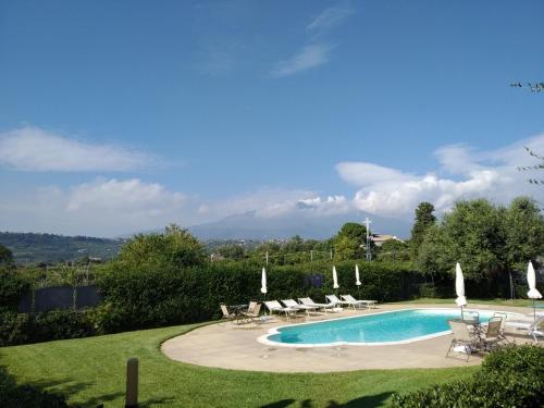a swimming pool in a yard with lounge chairs at Case Vacanze Residence Trinacria in Acireale