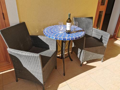 a table with a bottle of wine and two chairs at Al Baglio in Mondello