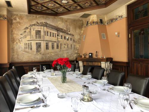 a table in a room with a painting on the wall at Motel M Vlasenica in Vlasenica