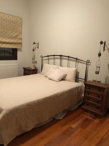 a bedroom with a bed and a wooden floor at Villa Dreamcatcher in Katochori