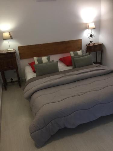 Una cama grande en una habitación con dos lámparas. en Chambres d'Hôtes Lovely Planette, en Nimes