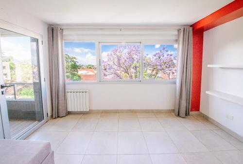 sala de estar con ventana grande y azulejos blancos en Amplio departamento en el centro de la ciudad en Salta