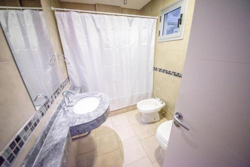ein Bad mit einem Waschbecken und einem WC in der Unterkunft Amplio departamento en el centro de la ciudad in Salta