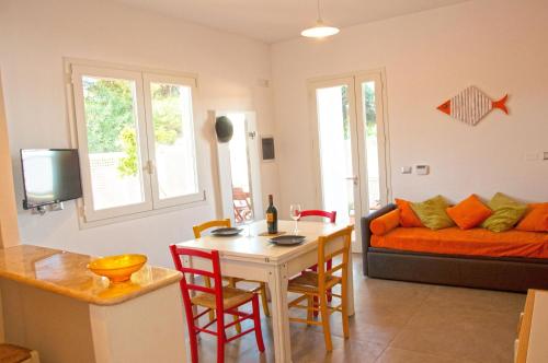 een woonkamer met een tafel en een bank bij Punta Prosciutto GMA Tourism in Porto Cesareo