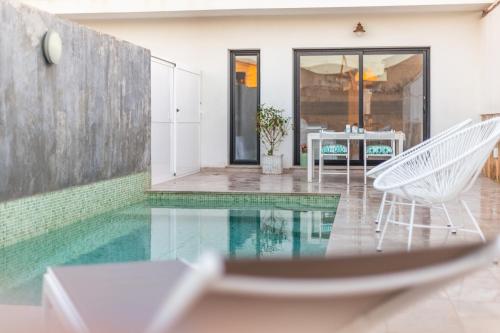 a swimming pool with two chairs and a table at Viles Can Moreno in Ses Salines