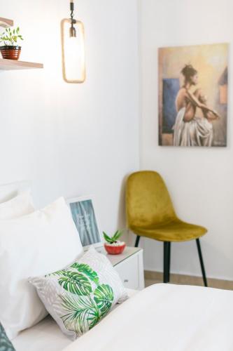 a bedroom with a bed and a yellow chair at Grand Lux Apartment in Serres