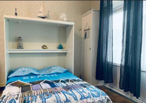 een slaapkamer met een bed met een blauw dekbed bij AMAZING BEACH & SUNSETS JUST 75m FROM THE BEACH! in Cadzand-Bad