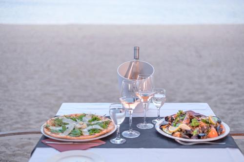a table with two plates of food and wine glasses at Marino Mobilhomes in Grimaud